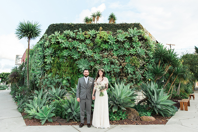 los-angeles-wedding-at-smogshoppe-bride-and-groom-standing-in-front-of-green-wall